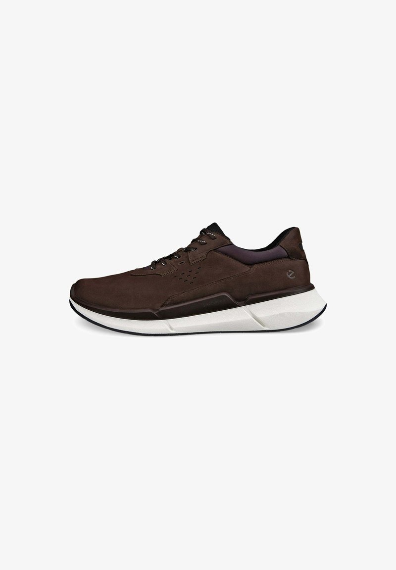 Bruine suède sneakers met een witte en zwarte zool, getextureerde accenten en geperforeerde details op het bovenwerk voor ademend vermogen.
