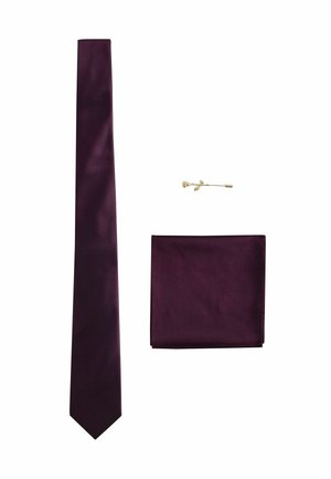 Dunkellila Seidenkrawatte, passendes Einstecktuch und goldene rosaförmige Anstecknadel auf weißem Hintergrund arrangiert.