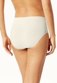 Mutande beige in cotone a vita alta con cintura elastica morbida e texture liscia, caratterizzate da una copertura totale e dettagli di cucitura minimali.