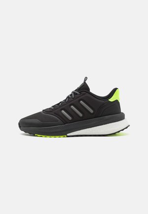 Zapatilla de running negra con parte superior de malla, tres franjas grises y un acento verde brillante. Presenta una suela blanca acolchada y una banda de rodadura texturizada.