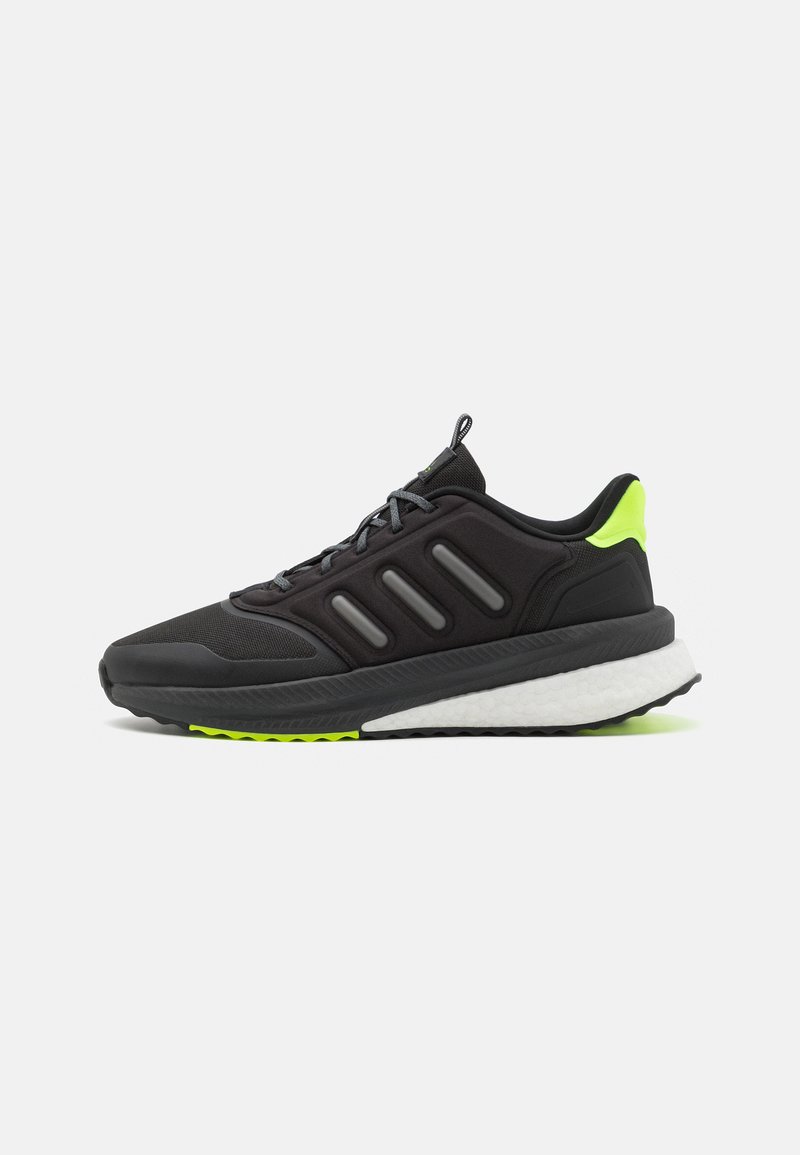 Zapatilla de running negra con parte superior de malla, tres franjas grises y un acento verde brillante. Presenta una suela blanca acolchada y una banda de rodadura texturizada.