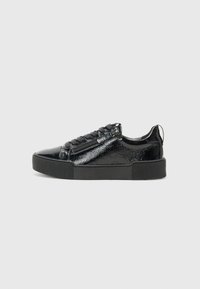Sneaker nera con tomaia in pelle verniciata lucida, punta rotonda, suola in gomma testurizzata e lacci piatti. Presenta una cerniera laterale per una facile vestibilità.