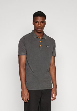 Polo gris de manga corta, con una tapeta de tres botones en naranja, costuras en contraste y un pequeño logotipo bordado en el pecho.