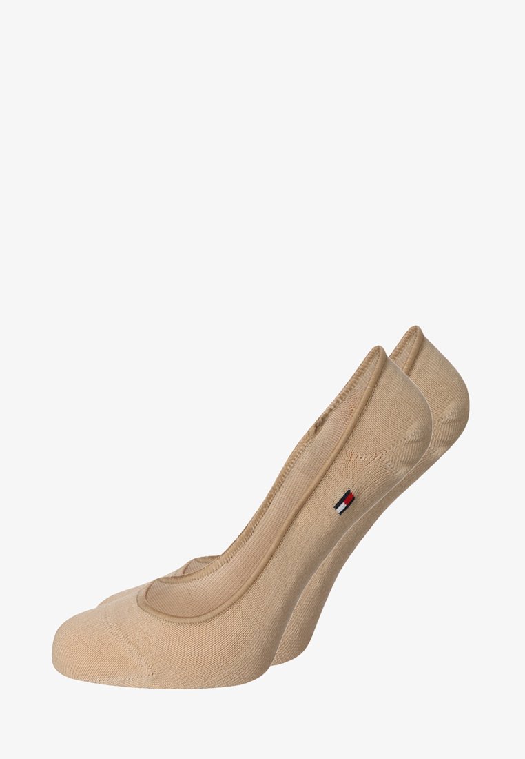 Beige ankle socks featuring a curved design, smooth texture, and a small logo accent in red, white, and blue near the cuff.