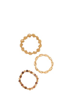 Trzy bransoletki z koralikami w odcieniach brązu i złota, każda z unikalnymi kształtami i fakturami koralików, ułożone na białym tle.