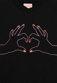 T-shirt in tessuto nero con un design di due mani che formano una forma a cuore, contornato di rosa con dettagli arancioni sulle punte delle dita.