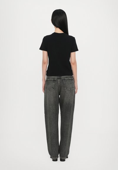 Black short-sleeve t-shirt paired with loose-fitting, faded grey jeans. Notable details include a high waist and casual straight-leg style.