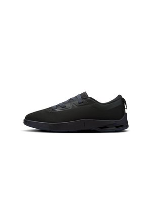 Baskets basses noires avec dessus en mesh, lacets minimalistes et semelle texturée, vues de profil sur un fond blanc.
