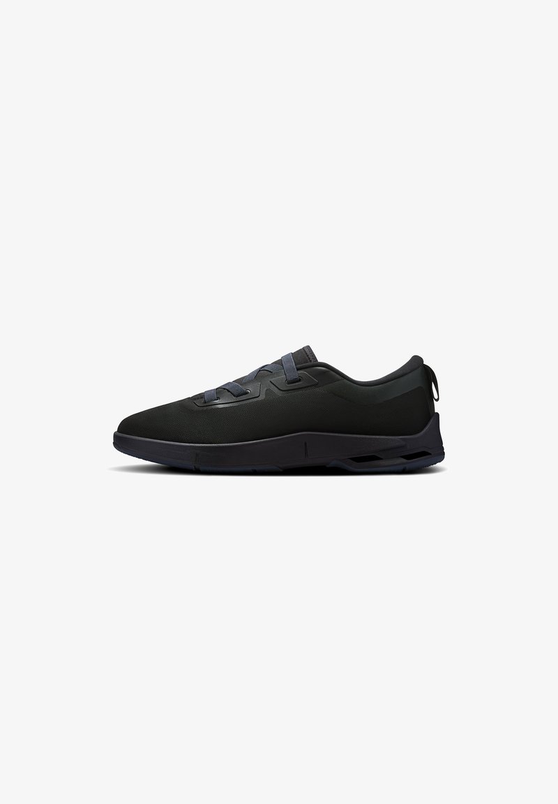 Baskets basses noires avec dessus en mesh, lacets minimalistes et semelle texturée, vues de profil sur un fond blanc.