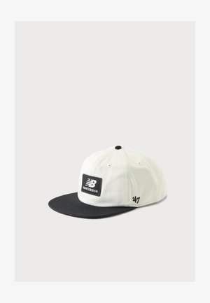 Weiße und schwarze New Balance Baseballkappe mit schwarzem Schirm und Patch-Logo vorne, abgebildet vor einem schlichten hellen Hintergrund.