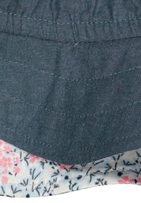 Gonna di jeans con orlo a fantasia floreale. Tessuto jeans blu scuro con cuciture texture sopra una base bianca decorata con fiori rosa e blu.