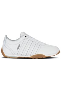 Bílé sportovní boty s hladkou koženou svrchní částí, se třemi vertikálními pruhy, gumovou podrážkou a polstrovaným límcem pro pohodlí.