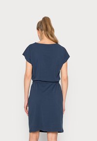 Mörkblå klänning med korta ärmar och rund halsringning, med ett elastiskt midjeband och knä-lång fåll, tillverkad av mjuk bomullstyg.