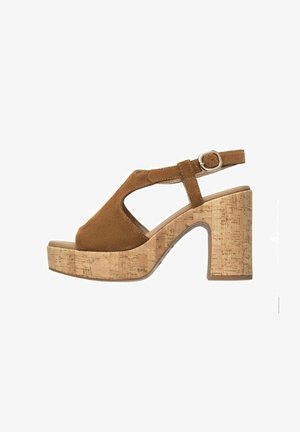 Brune ruskinds platform sandal med en korkblokhæl, åben tå og design med udsnit til svangen. Justerbar ankelrem med metalspænde.