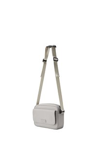 Pequeño bolso cruzado gris claro con correa ajustable beige, bolsillo con solapa en la parte frontal y compartimento principal con cremallera.