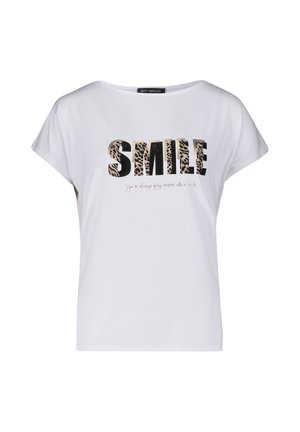 Biała koszulka z krótkim rękawem z napisem "SMILE" w pogrubionych czarnych literach z wzorem leopardzim, z mniejszym tekstem poniżej w stylu kursywy.