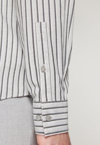 Gestreept shirt met lange mouwen in lichtgrijs en donkergrijs, met knoopmanchetten en een slim-fit pasvorm, gemaakt van een lichtgewicht stof.