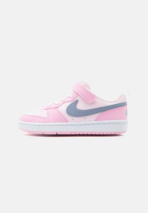 Pink-weißer Sneaker mit grauem Nike-Swoosh, Klettverschluss und weißer Sohle auf hellem, einfarbigem Hintergrund.