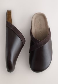 Sabots marron foncé à enfiler avec lanière croisée en suède et semelle intérieure beige matelassée marquée "NEXT", taille 6½/40, présentés en vues de dessus et de côté.