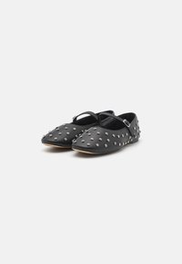 Black flats with a pointed toe, featuring silver stud embellishments, a slim ankle strap, and a soft leather texture.
