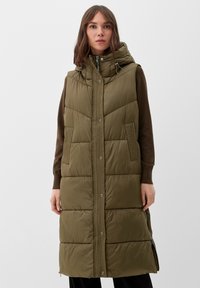 Olijfgroen, gewatteerde vest met een afneembare capuchon, voor sluiting met knopen en twee zijzakken. Bevat verticale stikdetails.