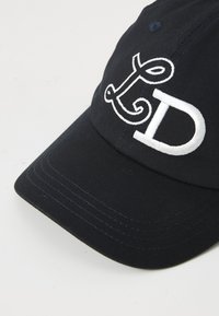 Marineblå baseballcaps med hvit brodert "LD"-logo. Har en buet skygge, sydd detaljer og bomullsstoff. Glatt tekstur.