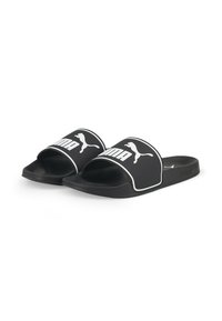 Sandales en caoutchouc noires à glissière avec une large sangle arborant le logo Puma en blanc et une surface texturée. Design ouvert au niveau des orteils et semelle plate.