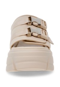 Beige platform sandaler med to justerbare stropper, metallic hardware detaljer og en tekstureret sål for ekstra greb og støtte.
