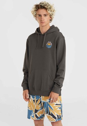 Dark gray hoodie with a kangaroo pocket, featuring a colorful sun and waves logo on the chest; paired with patterned yellow and blue shorts.