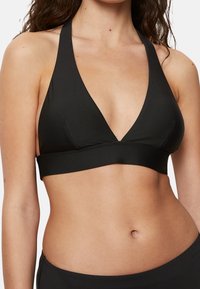 Mustat halterneck-tyylinen bralette, jossa on syvä v-pääntie, sile�ä pinta ja leveä vyötärö alareunassa. Yksinkertainen muotoilu, ei näkyvää metalliosaa.