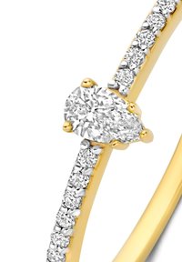 Gouden ring met een gepolijste afwerking, met een centrale ovale diamant en een band die is bezet met kleinere ronde diamanten aan één kant.