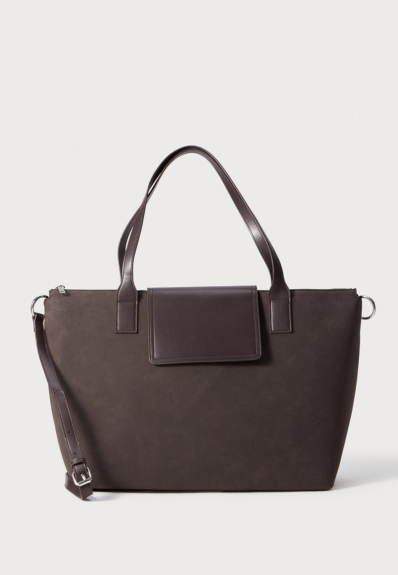 Brun tote bag laget av teksturert materiale, med to håndtak, en avtakbar skulderstropp og klaffelukking, med elegante søm detaljer.