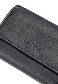 Dark grey leather wallet with a textured surface, featuring stitched edges and a debossed brand name, MAITRE, on the front.