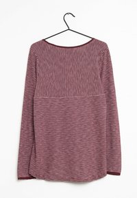 Lange mouw gebreide shirt met horizontale en verticale smalle witte strepen op gemarmerde stof, hangend aan een zwarte kledinghanger tegen een witte achtergrond.