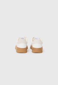 Hvite sneakers med en glatt, læraktig overdel og beige detaljer, som har en gummisåle, rund form og polstret krage.