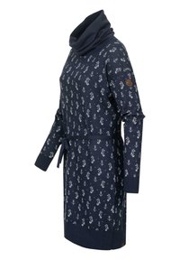 Tamsiai mėlyna megztinė su apvalia kaklo iškirpte, su balta jūrine inkaru ir jūrgelmiu dekoru, susieta liemens srityje su atitinkamu diržu.