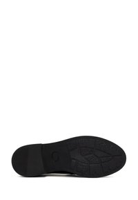Suela de zapato de goma negra con un patrón de agarre texturizado, que presenta una punta redondeada y un ligero tacón, diseñada para ofrecer tracción y durabilidad.