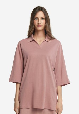 Oversized lyserød polo shirt med v-hals, korte ærmer og en blød tekstur. Har en glat krave og en afslappet pasform.