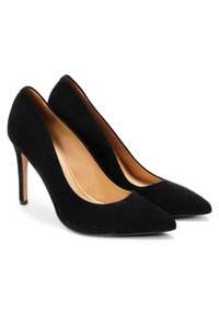 Juodos suede aukštakulnės bateliai su smailiu priekiu ir elegantiška siluetu. Vidinė pamušalo spalva kontrastuoja su šviesiai beige.
