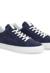Navy blue suede sneakers with white laces, textured upper, and rubber sole. Features a subtle logo label on the heel.