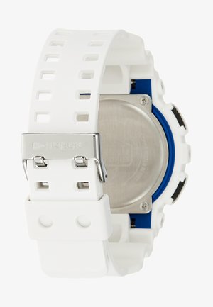 Montre en résine blanche avec un bracelet texturé, des accents bleus, un boîtier arrière en acier inoxydable et une boucle argentée portant une gravure "G-SHOCK".
