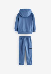 To-delt outfit i blå: en hættetrøje med en glat tekstur og matchende joggers med elastisk talje og sidelommer.