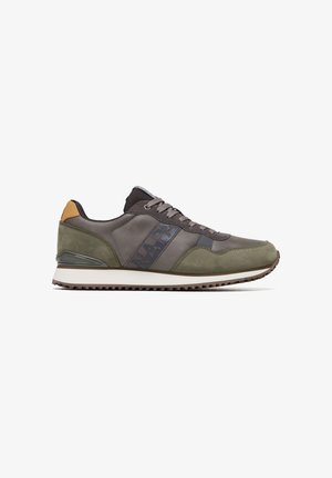 Mørke olivengrønne sneakers med grå accenter, der har en tekstureret overdel i ruskind og læder, en hvid mellemsål og snørelukning.