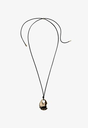 Ogrlica s črnim vrvico, ki ima velikega, poliranega zlatega kovinskega obeska z nepravilno obliko in majhno luknjo za pripenjanje.