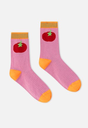 Chaussettes violettes avec les orteils, les talons et les bords oranges, chacune présentant une tomate rouge avec une tige verte près du haut.
