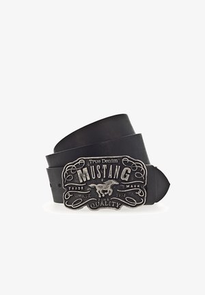 Ceinture en cuir noire avec une grande boucle argentée représentant un cheval au galop et le texte "Mustang True Denim Trade Mark Fine Quality."