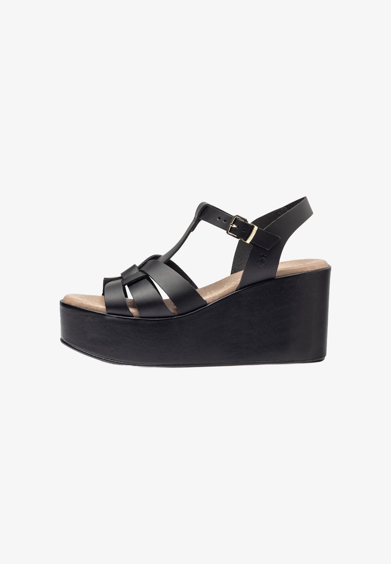 Black wedge sandal featuring a platform design, multiple leather straps, ankle strap with a buckle, and a textured sole.
