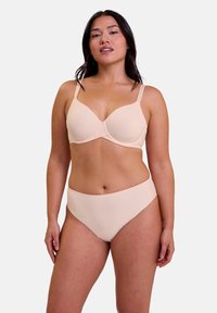 Soutien-gorge beigne rembourré avec bretelles réglables et finition lisse, accompagné d'un slip taille haute assorti au design sans coutures.