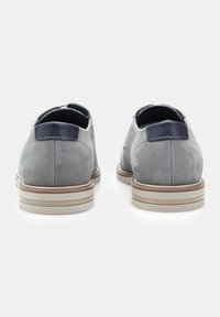 Pantofi gri din suede cu un capăt neted, accente bleumarin și o talpă bej cu dungi orizontale subtile. Toc rotunjit, design minimalist.