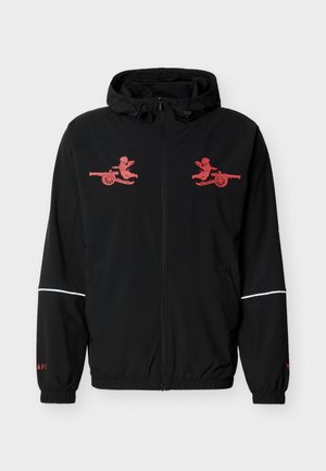 Μαύρο φούτερ με φερμουάρ και κουκούλα, με κόκκινες εικόνες χερουβείμ και κανόνι στο στήθος και αντανακλαστικές ρίγες στα μανίκια. Ελαστικές μανσέτες και τελείωμα.